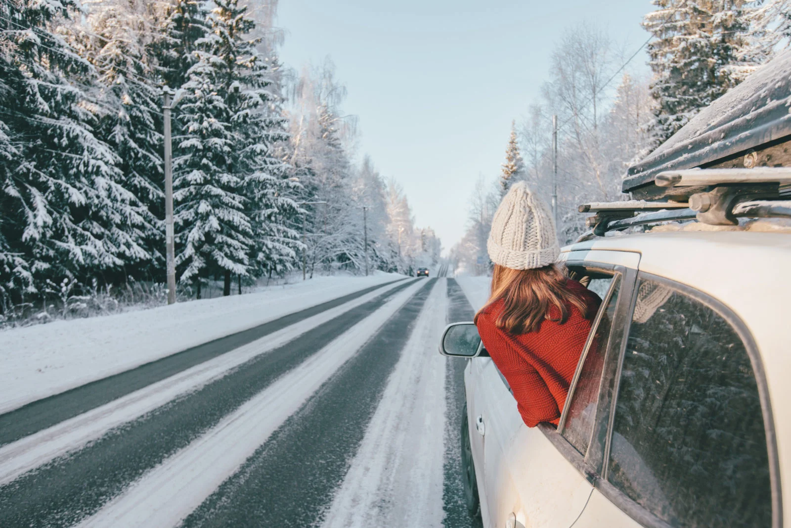 Magic car trip on the road by winter forest covered by snow