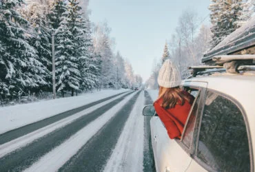Magic car trip on the road by winter forest covered by snow